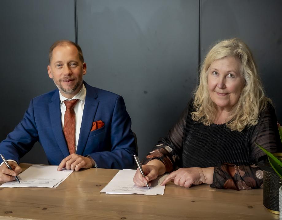 Man en vrouw ondertekenen een overeenkomst.